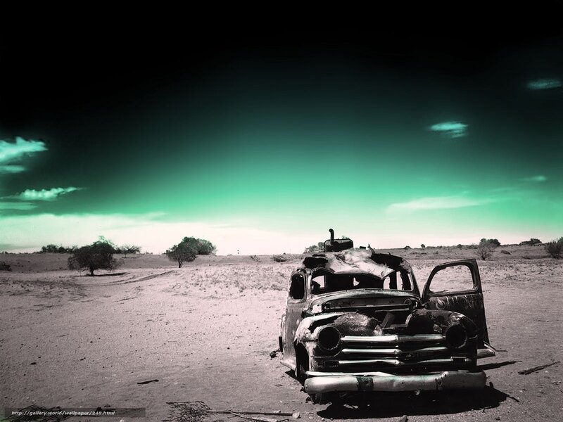 Burnt car in desert landscape