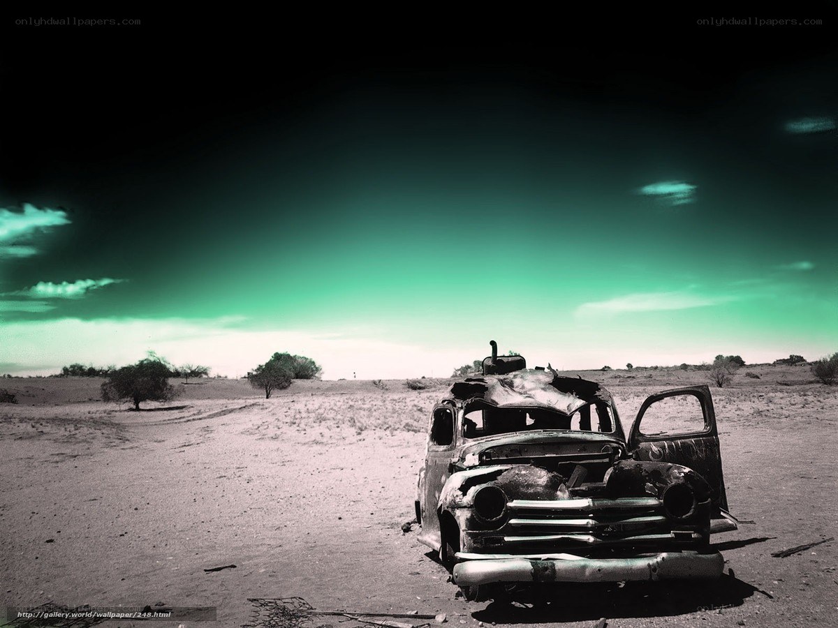 Burnt car in desert landscape