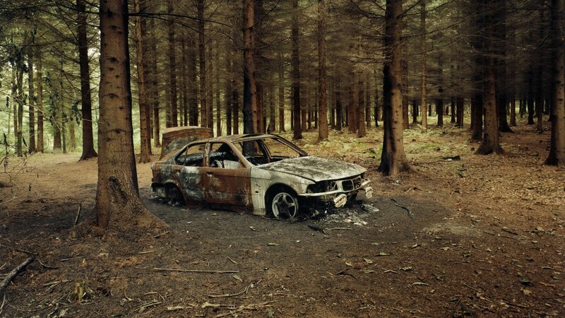Burnt car in forest