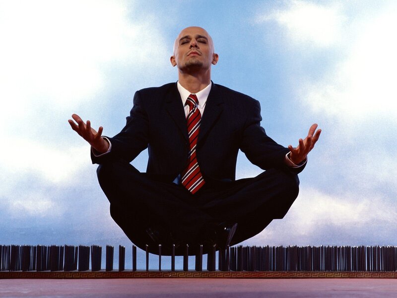 Businessman meditating above spikes