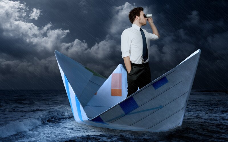 Businessman on paper boat in storm