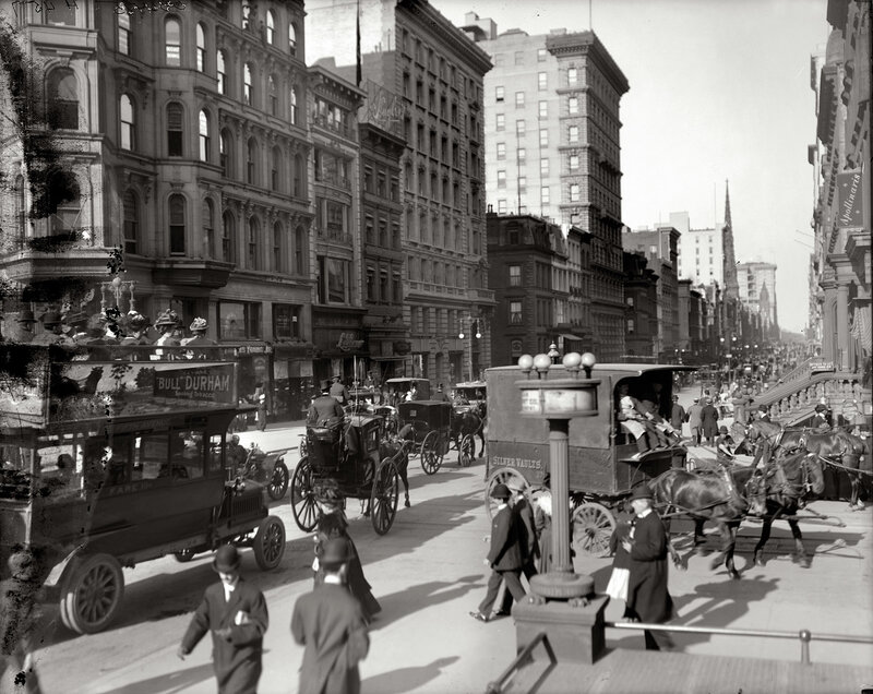 Busy city street with horse-drawn carriages