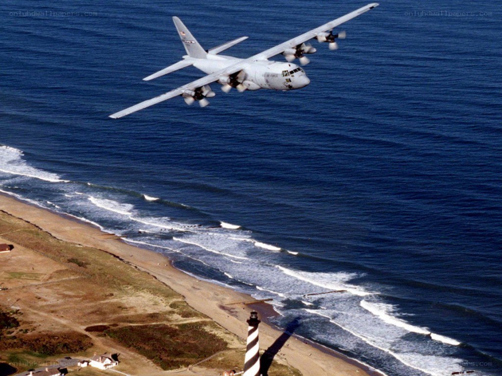 C-130 Hercules over coastal lighthouse