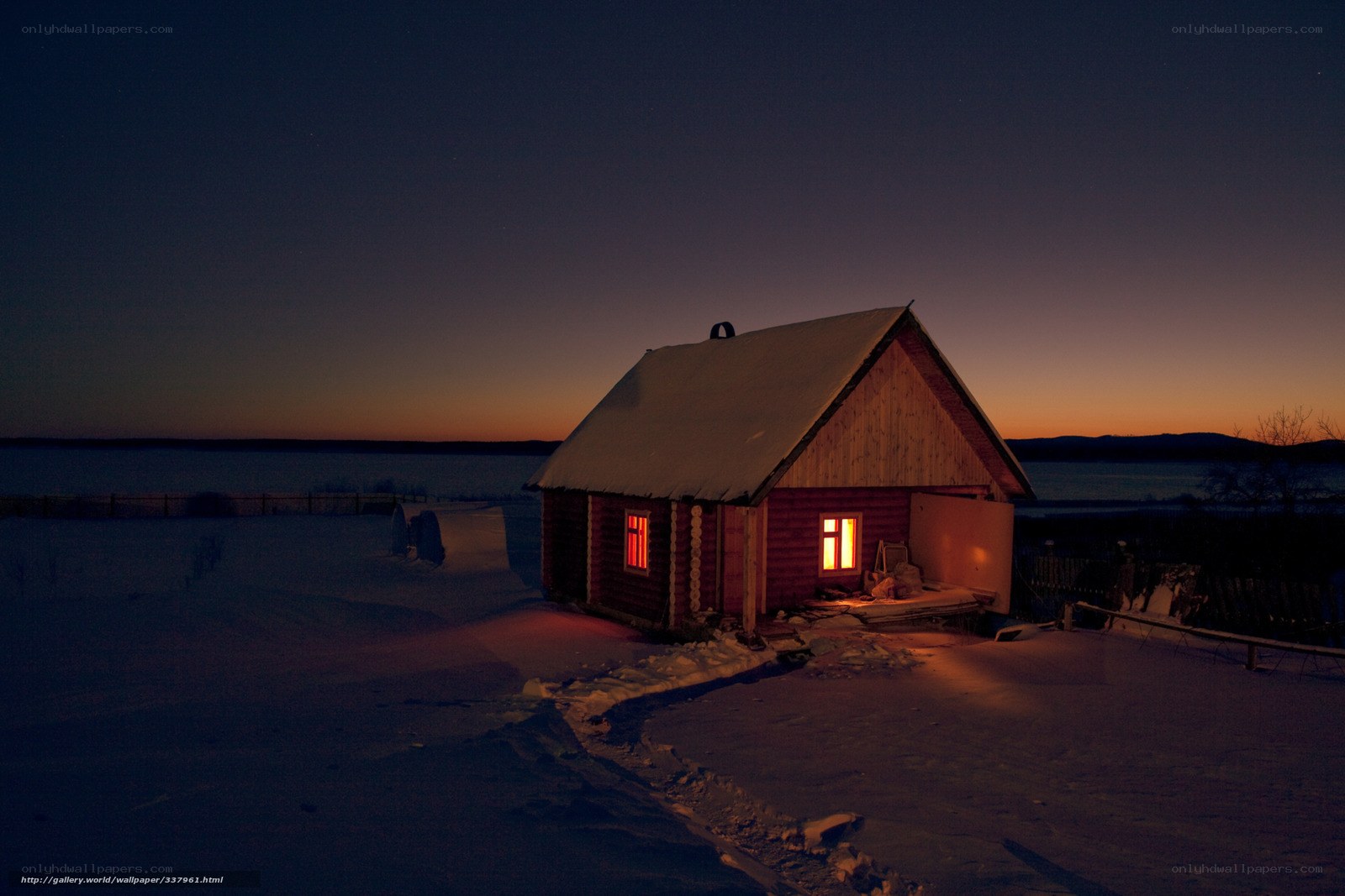 Cabin at dusk in snowy landscape