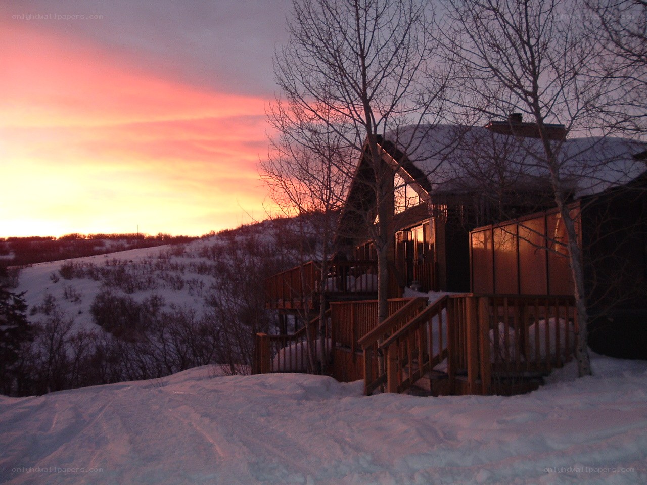 Cabin at sunset in snowy landscape