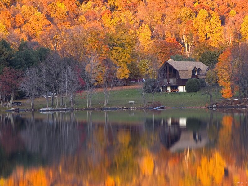 Cabin by a lake in autumn