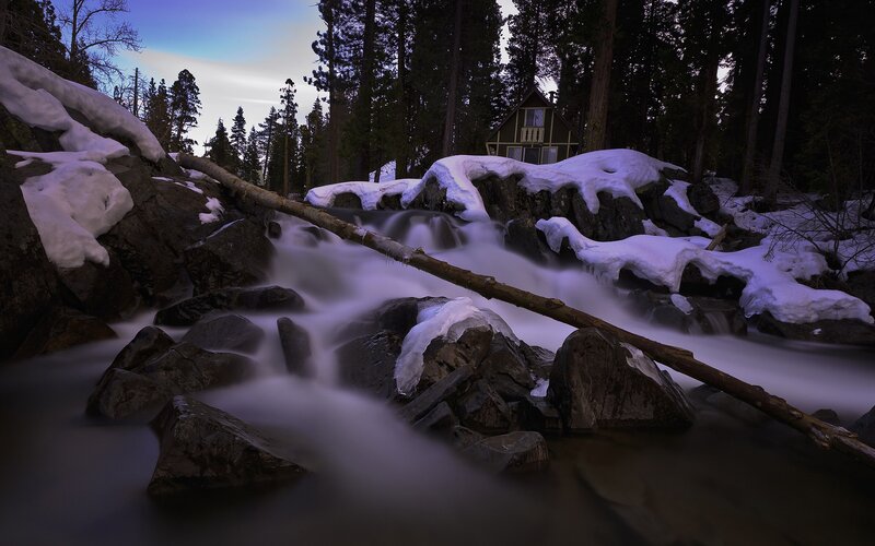 Cabin by a snowy stream