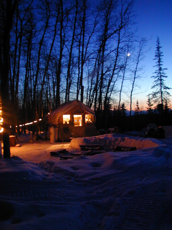 Cabin in snowy forest at dusk