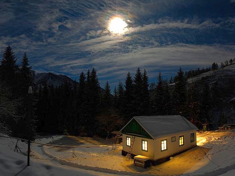 Cabin in snowy mountains at night
