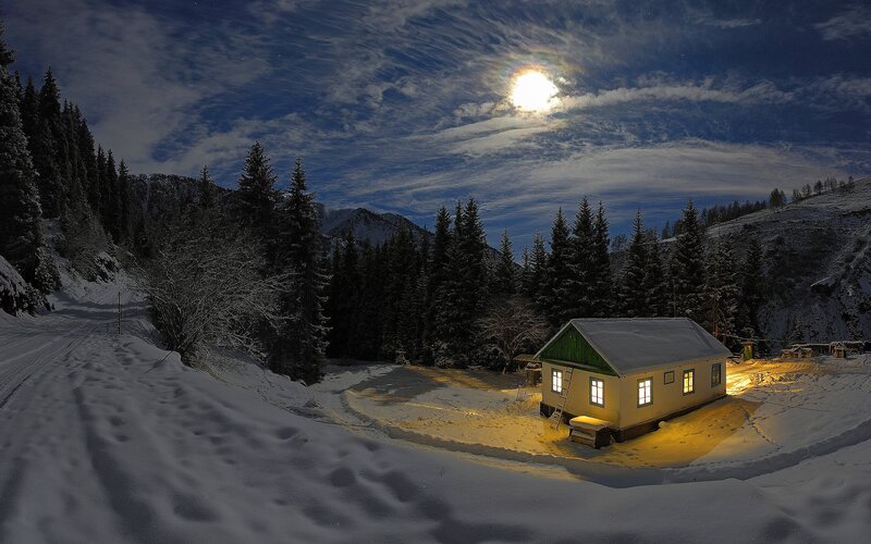 Cabin in snowy mountains at night