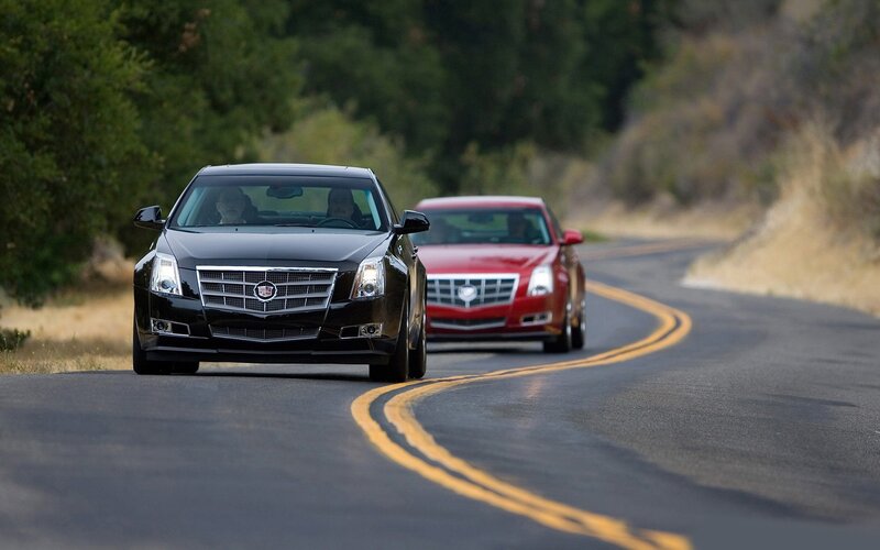 Cadillac cars on a winding road