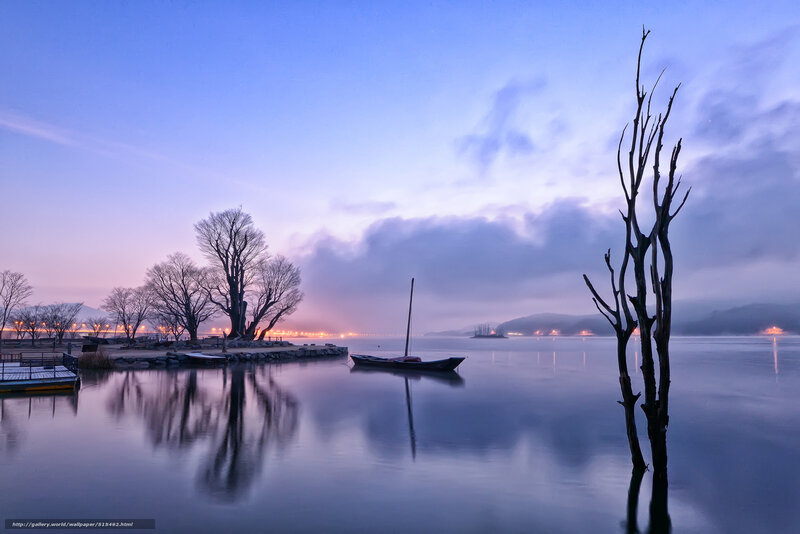 Calm lake at dawn with boats