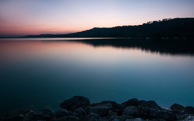 Calm Lake at Dusk — Blue, Serene, Sunset, Photograph, Rocks, Hills