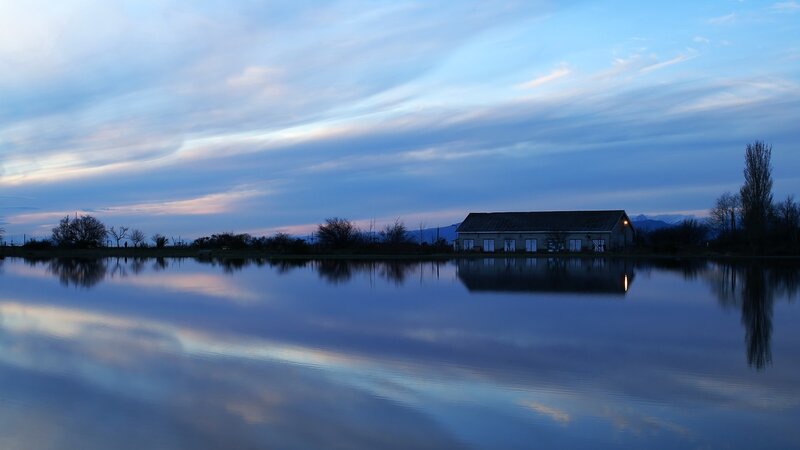 Calm lake at dusk with building