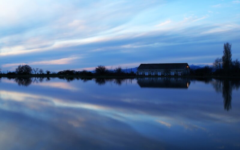 Calm lake at dusk with building
