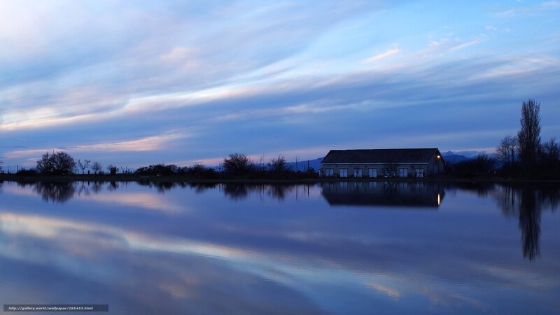 Calm lake at dusk with building