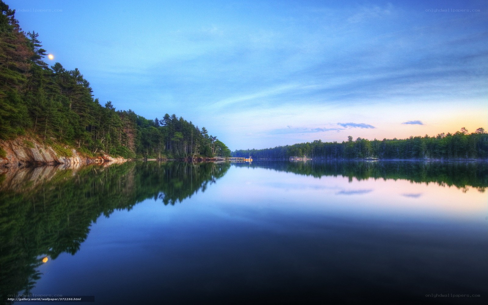 Calm lake at dusk with moon