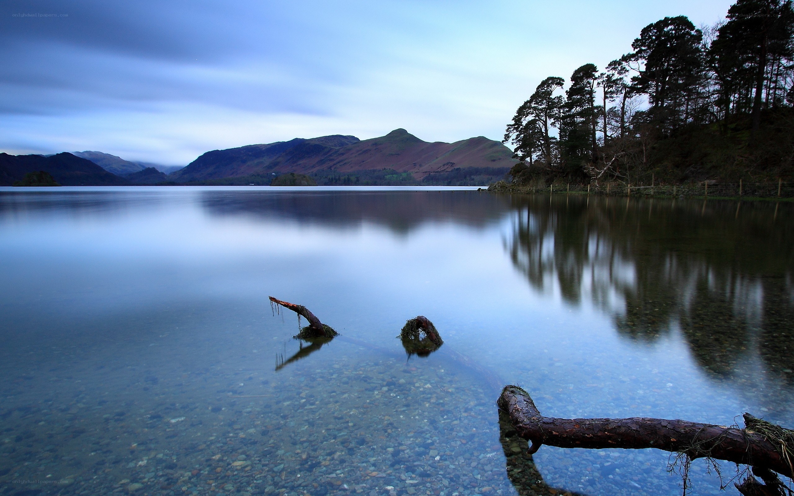 Calm lake at dusk with mountain reflection