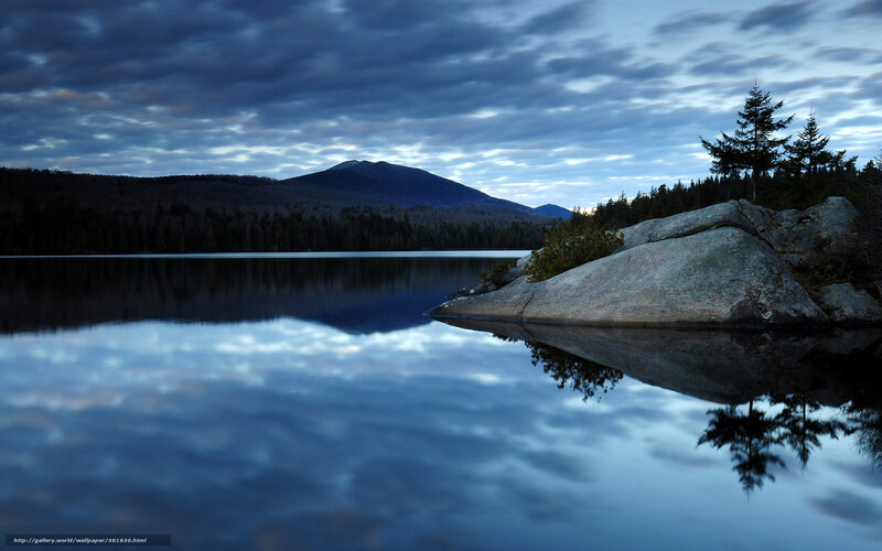 Calm lake at dusk with mountain reflection