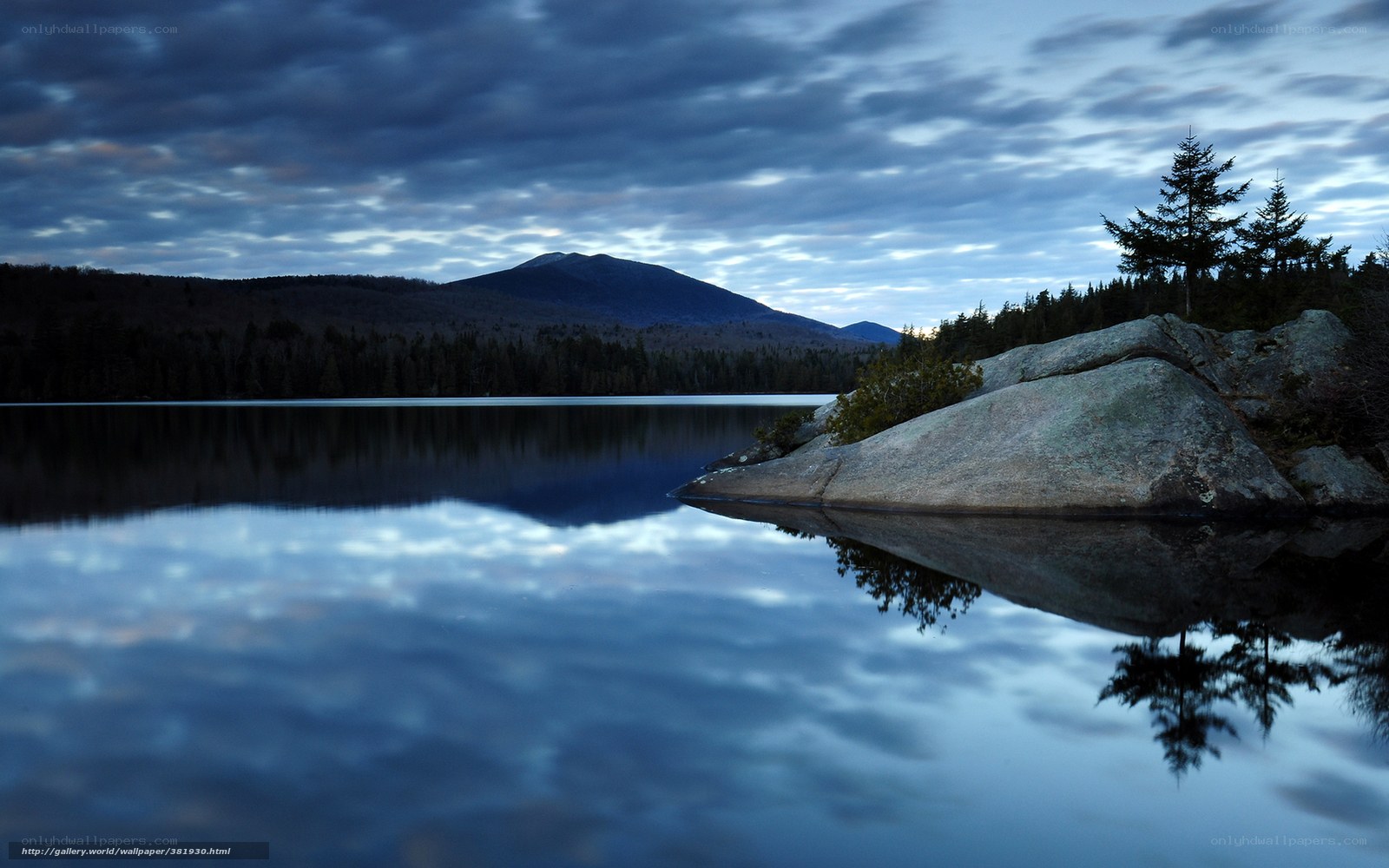 Calm lake at dusk with mountain reflection