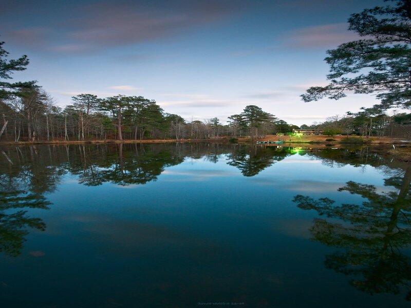 Calm lake at dusk with tree reflections