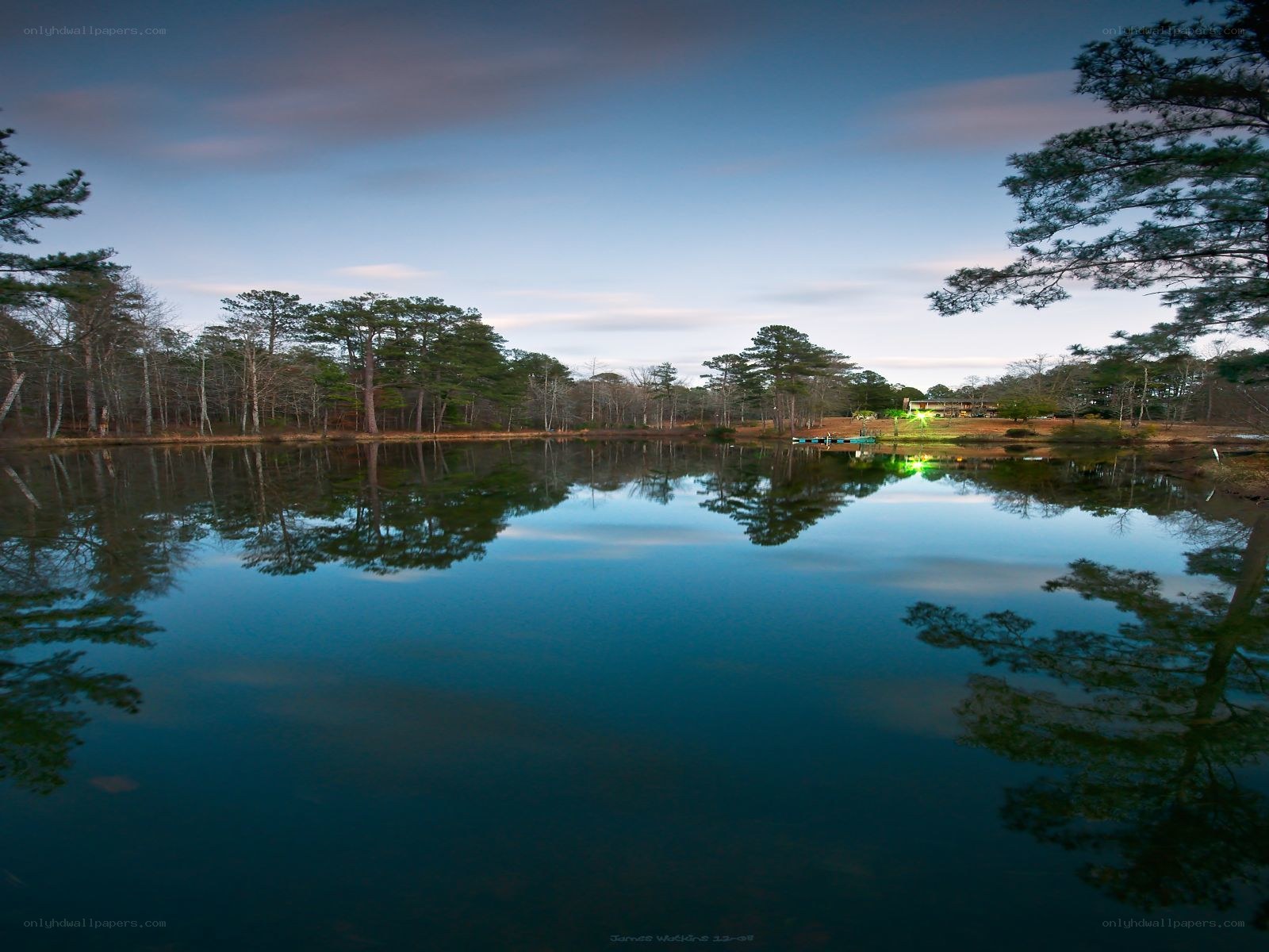 Calm lake at dusk with tree reflections