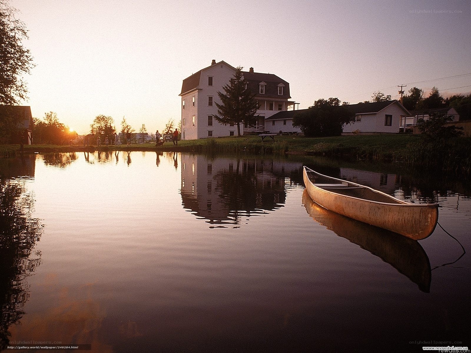 Calm lake at sunset with house
