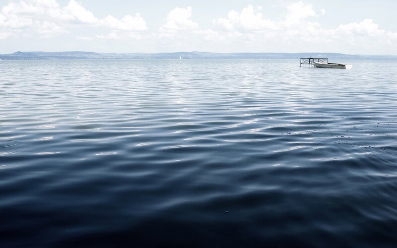 Calm lake with boat and distant hills