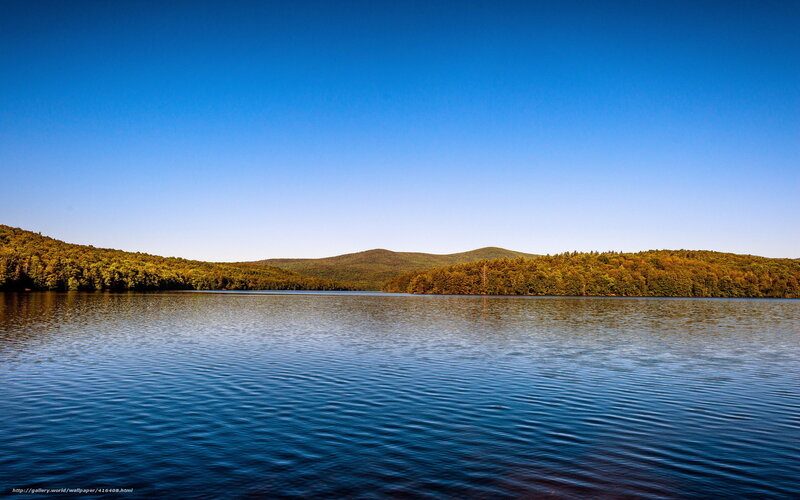 Calm lake with forested hills