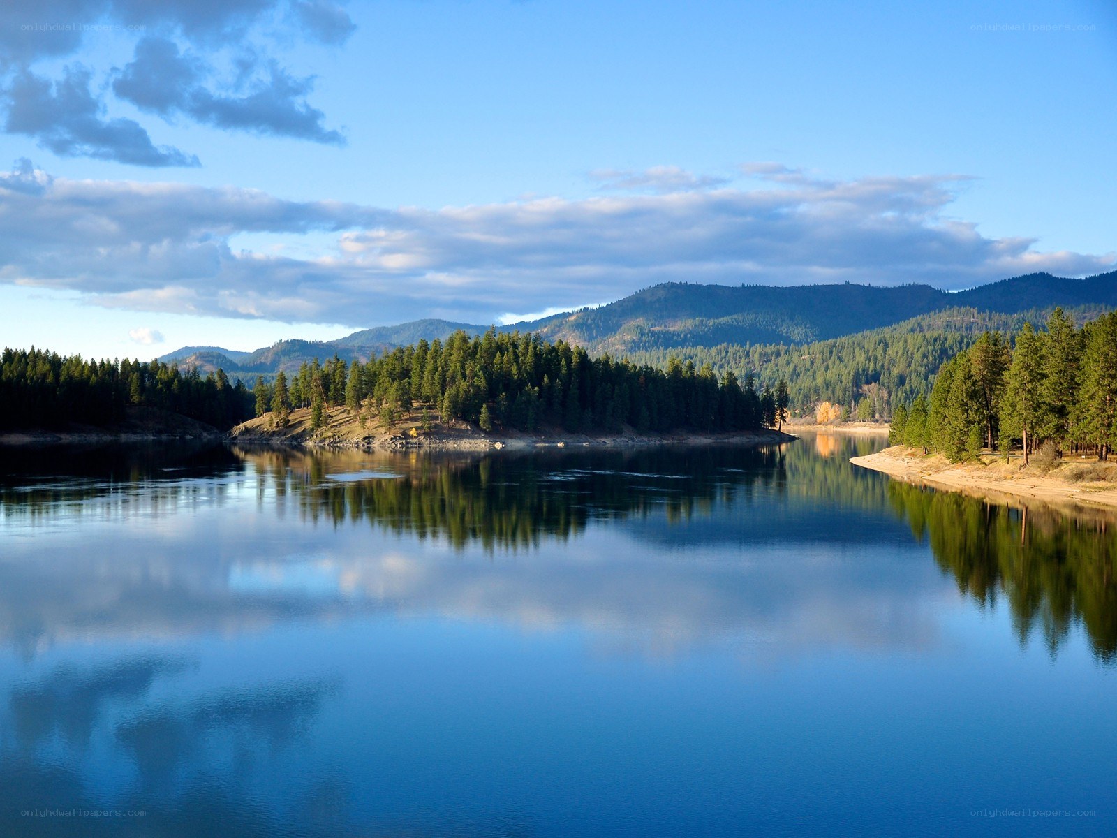 Calm lake with forested mountains