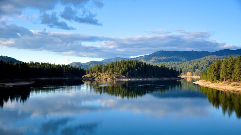 calm lake with forested mountains