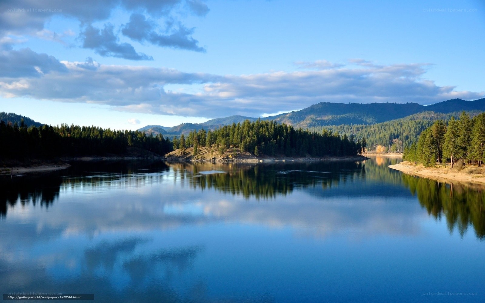 Calm lake with forested mountains