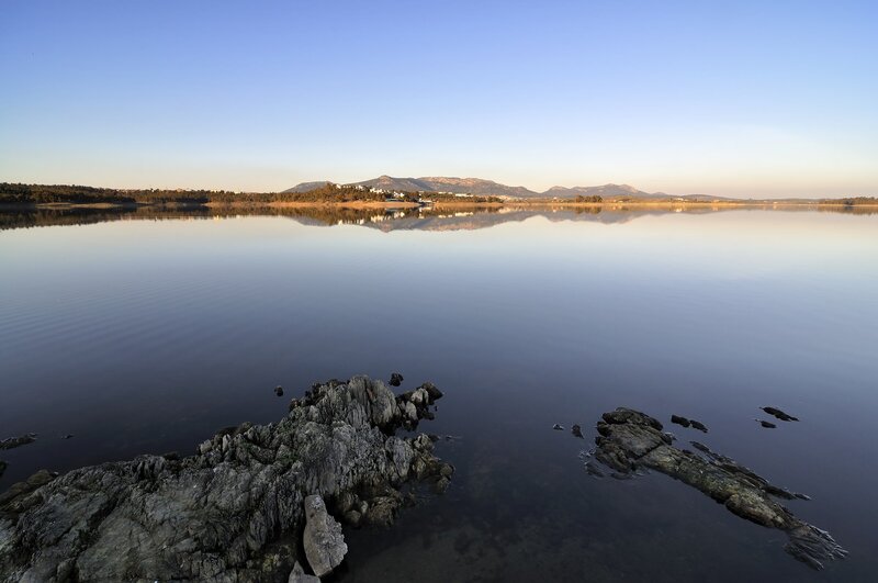 Calm Lake with Mountains — Blue, Serene, Morning, Photograph, Rocks