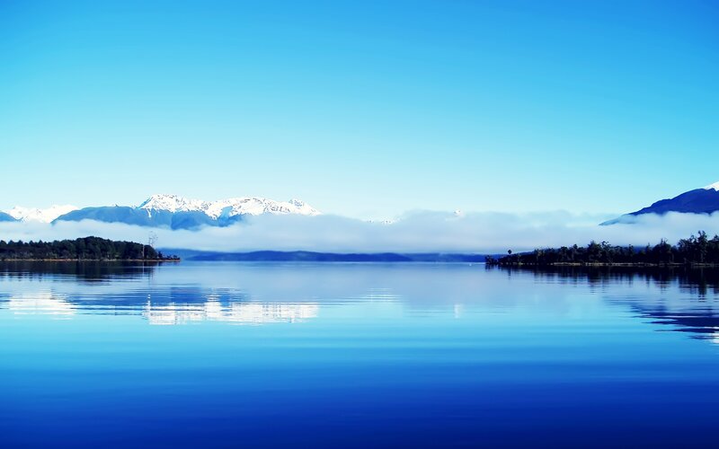 Calm lake with snow-capped mountains