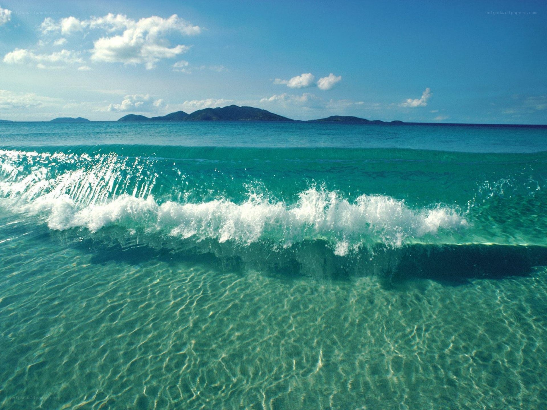 Calm ocean wave with distant islands