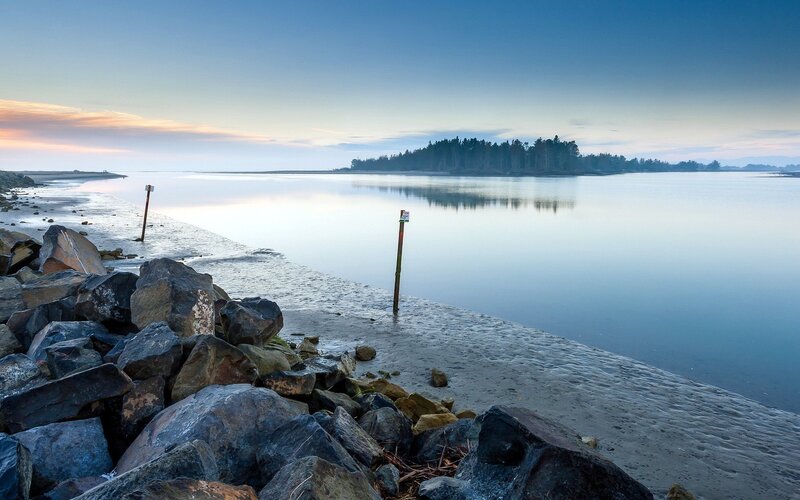 calm river at dawn with rocky shore