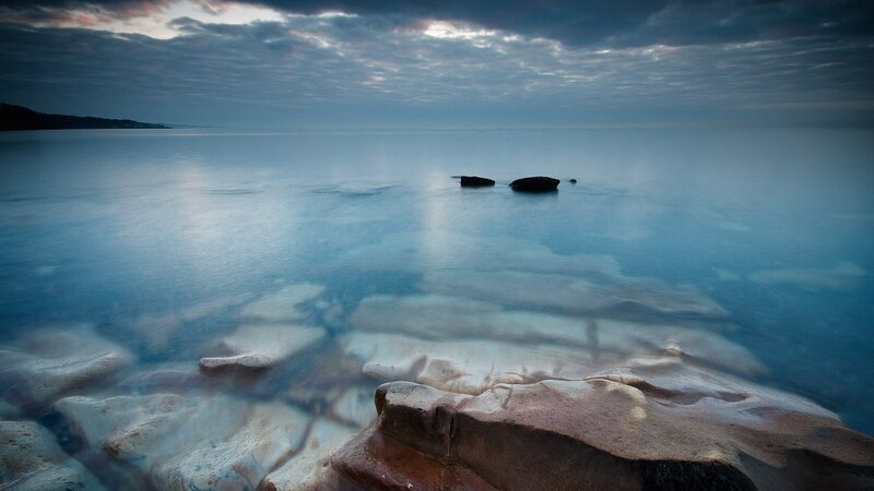 calm sea at dusk with rocks