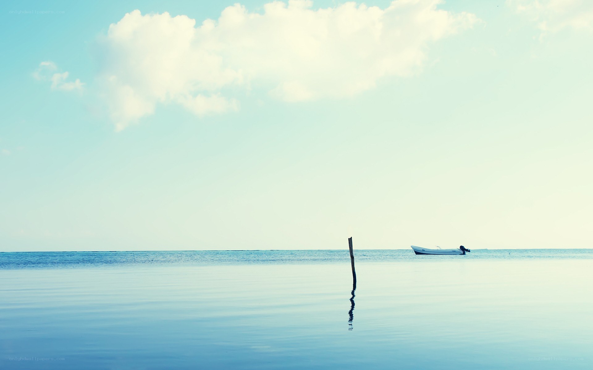 Calm sea with boat and post