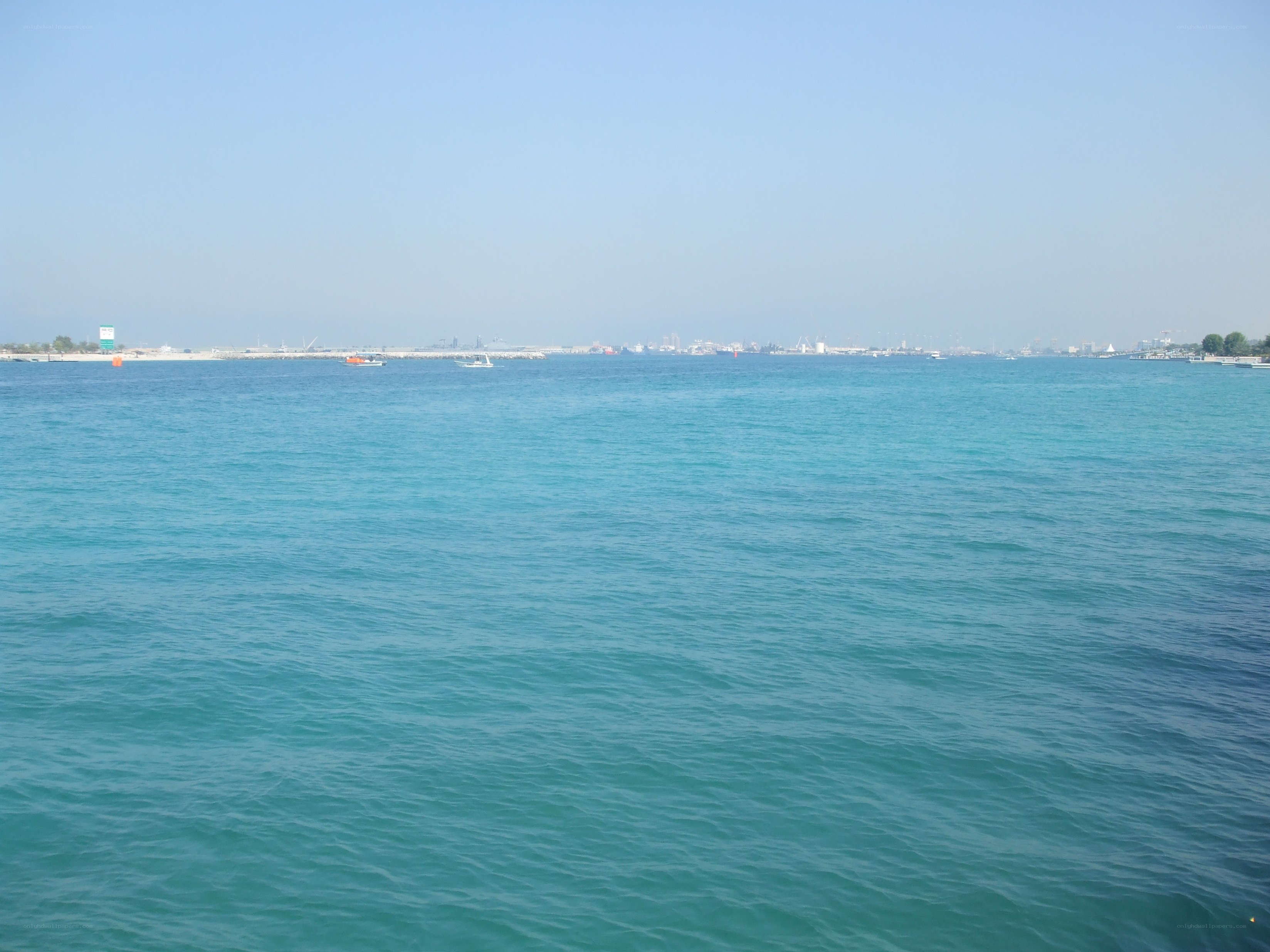 calm sea with distant cityscape