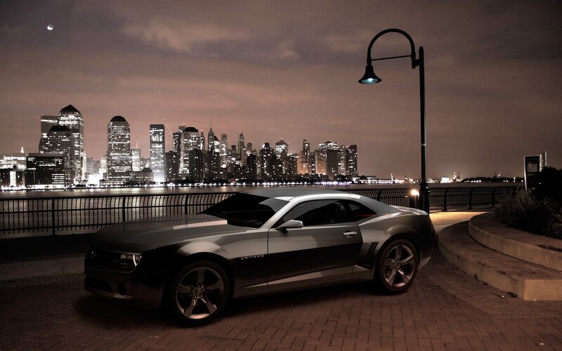Camaro at night with city skyline