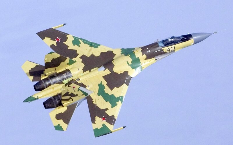 camouflage fighter jet in flight