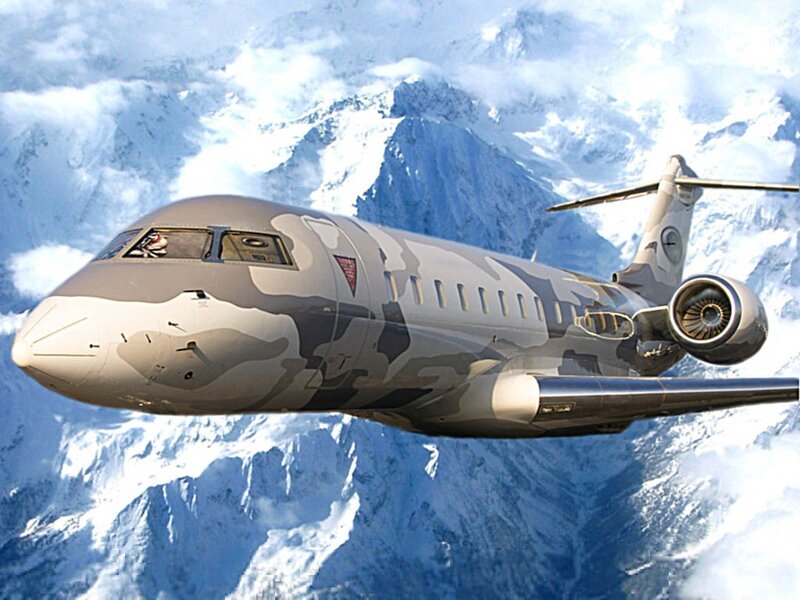 camouflage jet over snowy mountains