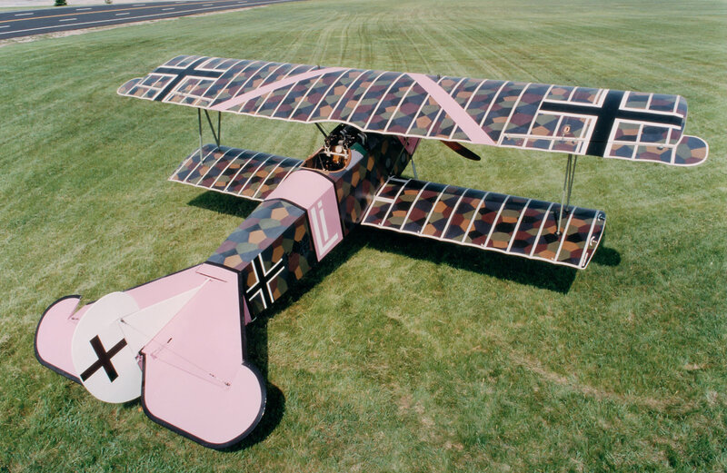camouflaged biplane on grass