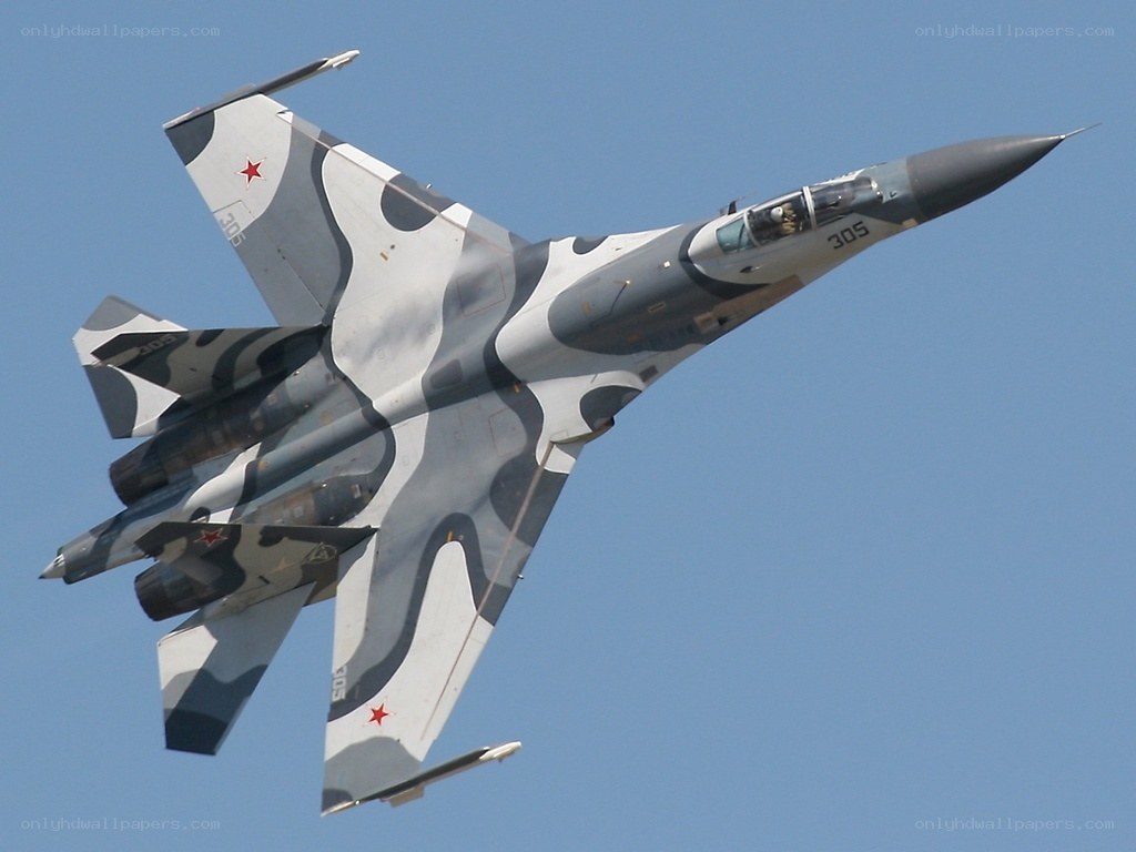 camouflaged fighter jet in flight