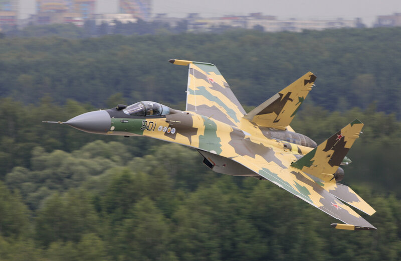 camouflaged fighter jet in flight