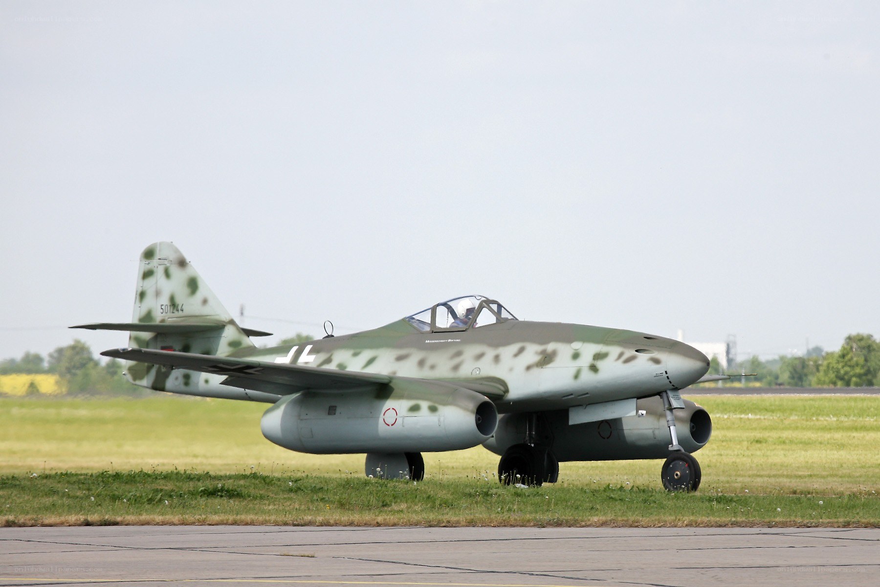 camouflaged jet on airfield