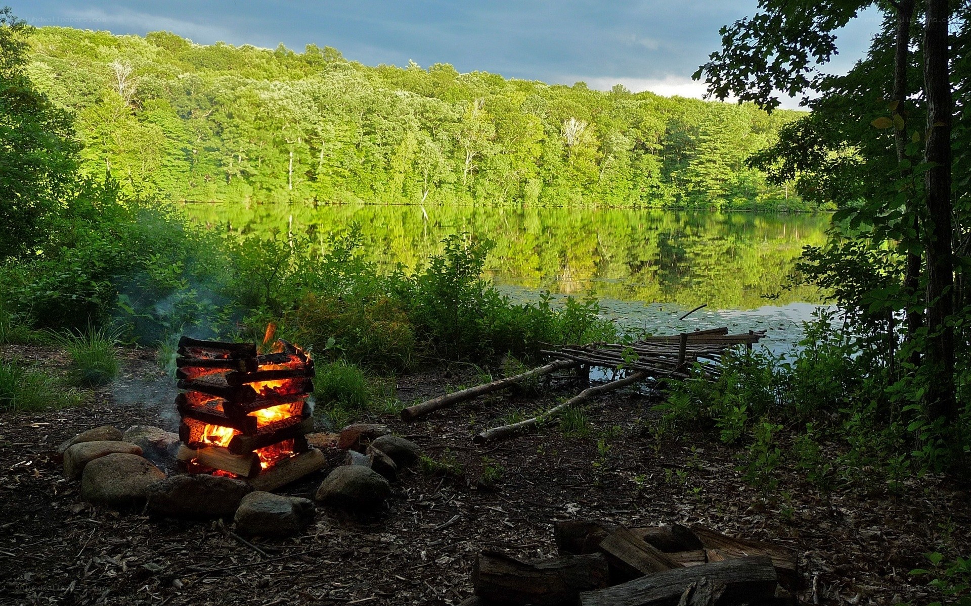 Campfire by a forest lake