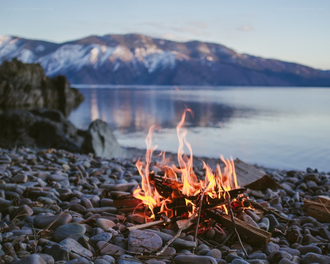 Campfire by a lake at dusk