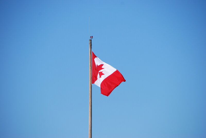 Canadian flag waving in blue sky