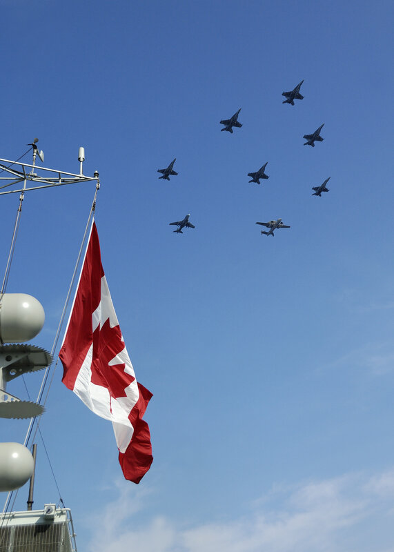 Canadian flag with jets flying overhead